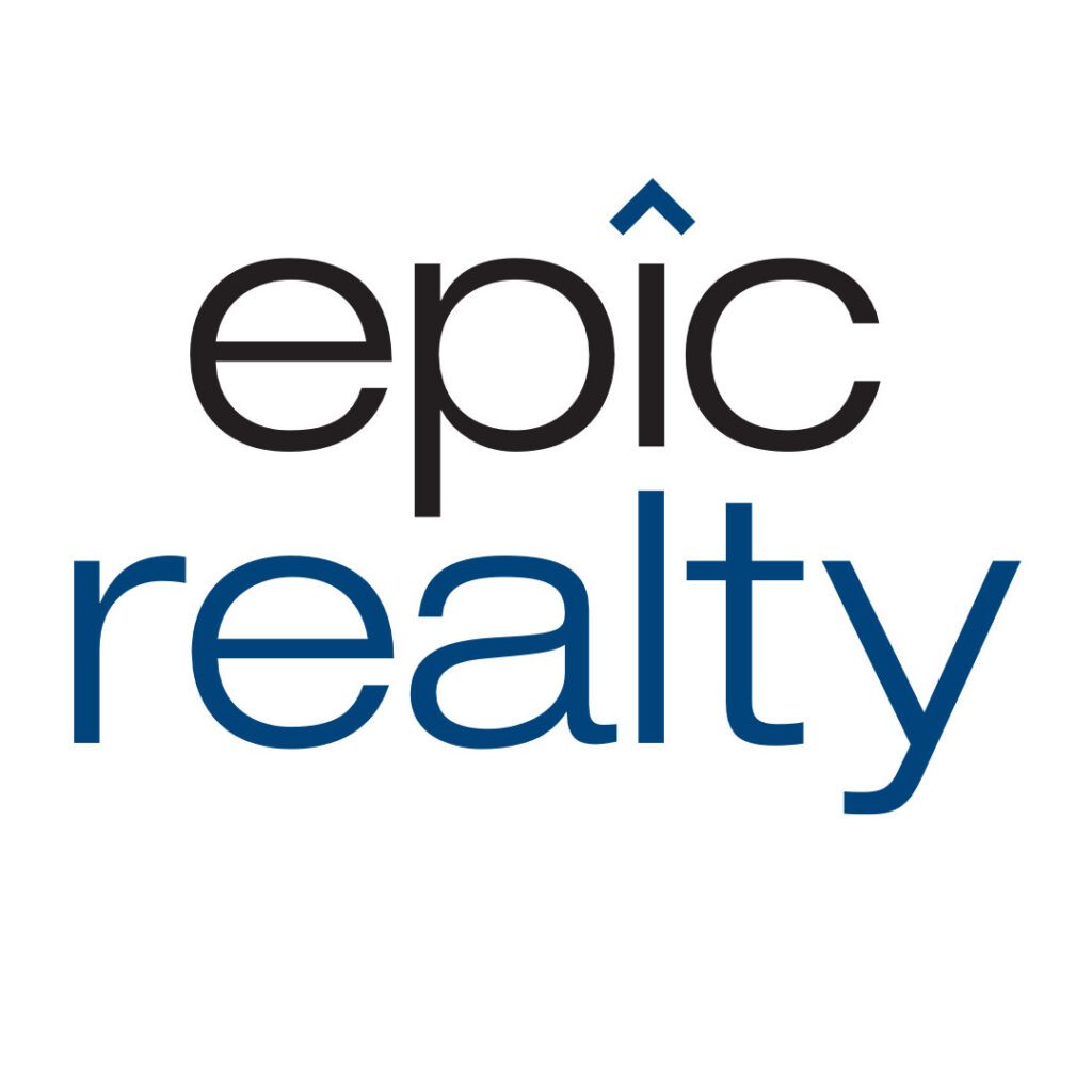 Logo design for Epic Realty. The word ‘epic’ is rendered in a clean, modern sans-serif typeface in black and dark blue lowercase letters, with a stylised circumflex accent placed above the letter ‘i’, subtly evoking the silhouette of a rooftop. Below it, the word ‘realty’ appears in a larger font size and navy blue colouring, also in lowercase, with consistent typographic style. The overall composition conveys clarity, contemporary professionalism, and a subtle architectural motif appropriate for a real estate brand.