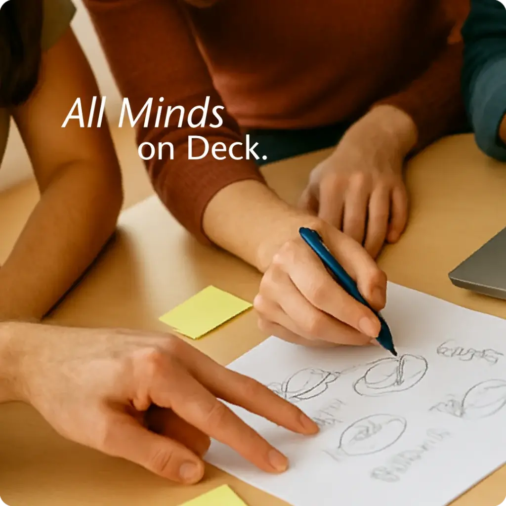 Four professionals actively collaborating around a laptop and sketches, symbolising swarming in a brand strategy session.