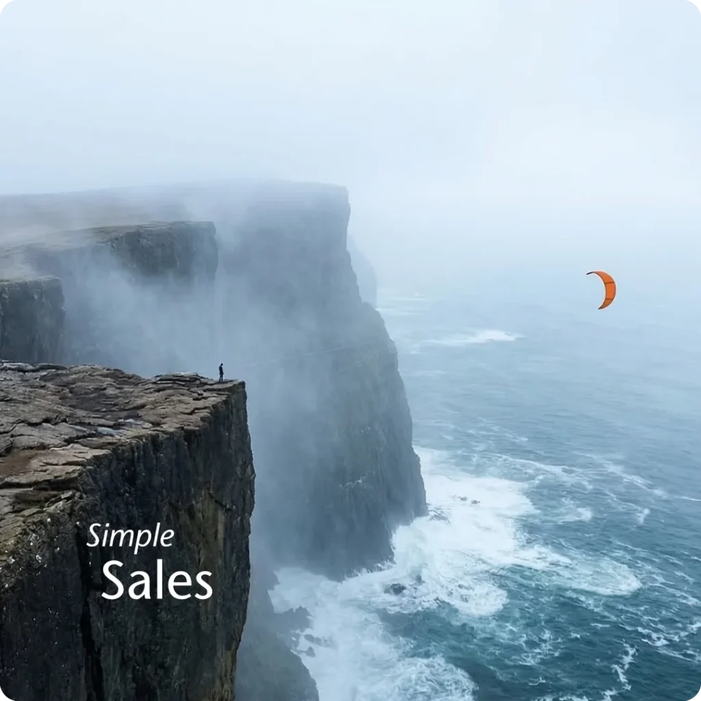 A defined product strategy yields stability, shown through a microscopic human speck near the vast precipice edge of the massive rocky headland, successfully flying the orange kite which appears as a realistic small speck against the massive natural background.